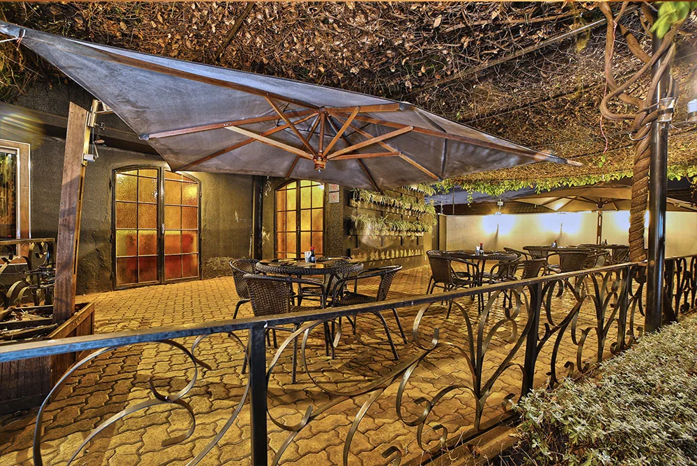 Varanda do restaurante com mesas e vista para a área externa